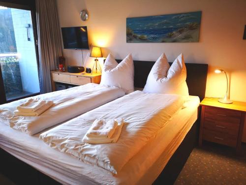 - une chambre avec un grand lit blanc et des serviettes dans l'établissement Apartment in Bad Grund (Harz), à Bad Grund