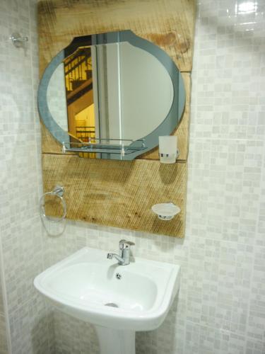 a bathroom with a sink and a mirror at The Rolé House in Gurjaani