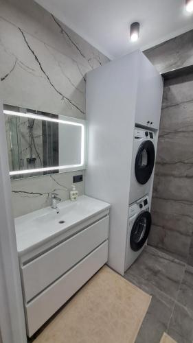 een badkamer met een wastafel en een wasmachine bij АЭРОПОРТ-НОМЕРА-ТАКСИ-ПАРКИНГ in Chişinău