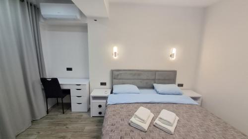 una camera da letto con un letto con due asciugamani bianchi di АЭРОПОРТ-НОМЕРА-ТАКСИ-ПАРКИНГ a Chişinău