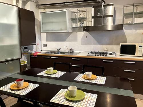 eine Küche mit einem Tisch mit zwei Tassen drauf in der Unterkunft Appartamento - casolare Bologna in Bologna