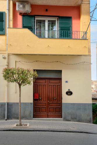 a building with a brown door and a balcony at Sikelìa in Nicosia