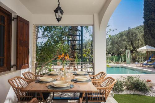 a dining room with a table and chairs and a pool at MyThea Villa by "elite" in Lithakia