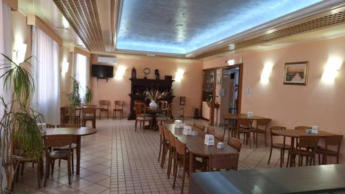 a restaurant with tables and chairs in a room at HOTEL PERLA in Massa Lombarda