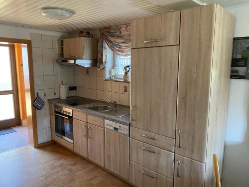 a kitchen with wooden cabinets and a sink at Ferienhaus-Pahl-in-Wolfshagen in Wolfshagen