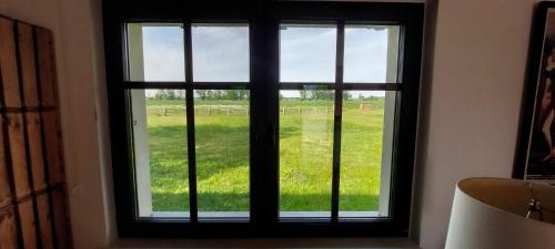 ein Fenster mit Blick auf ein Grasfeld in der Unterkunft SOHL FARM in Neutrebbin