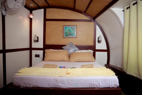 a bedroom with a bed with an arched ceiling at Thara's Houseboat in Alleppey