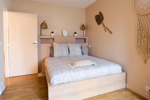 een kleine slaapkamer met een bed met witte lakens bij Zenitude Balnéo Hypercentre Melun in Melun