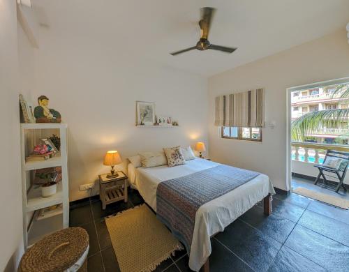 1 dormitorio con 1 cama y ventilador de techo en Villa Candolim, en Candolim