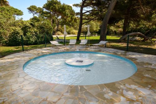 a circular pool in the middle of a park at Le studio de giens in Hyères