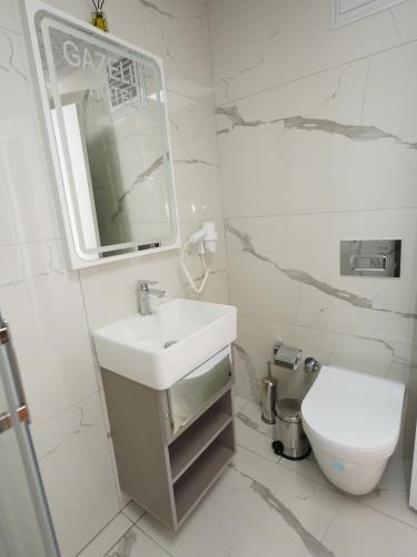 a white bathroom with a sink and a toilet at gazelle suites in Istanbul