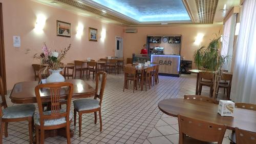 a dining room with tables and chairs in a restaurant at HOTEL PERLA in Massa Lombarda