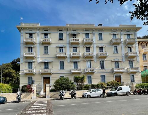 een groot wit gebouw met auto's geparkeerd voor het bij La Terrazza di Shelley Panoramic Flat in Lerici