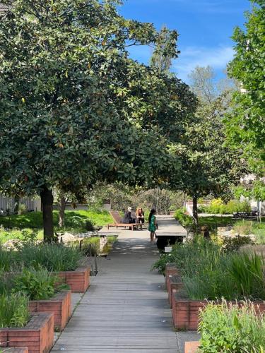 people sitting on benches in a park with trees at Parisian style apartment in Maisons-Alfort