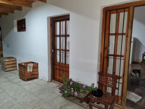 Zimmer mit zwei Türen, einer Bank und Blumen in der Unterkunft La Blanca in Mercedes