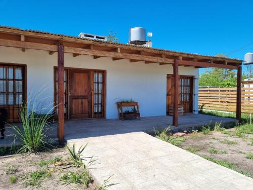 eine Veranda eines Hauses mit einem Holzdach in der Unterkunft La Blanca in Mercedes