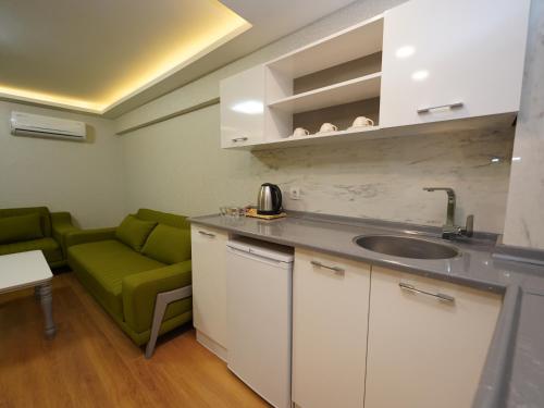 a kitchen with a sink and a green couch at gazelle suites in Istanbul