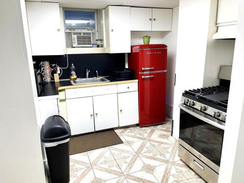 a kitchen with a red refrigerator and a sink at Manhattan in 2 stopages, 2 Bedrooms Apt with private Backyard in LIC !!! in Long Island City