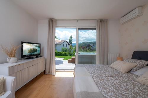 1 dormitorio con 1 cama, TV y ventana en Luxury Apartment Nana, en Bled