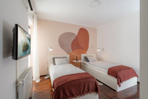 a bedroom with two beds and a flat screen tv at Luxury Apartment Nana in Bled