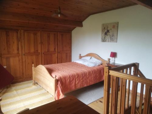 - une chambre avec un lit et un escalier en bois dans l'établissement Gîte de la glycine, à Marmande