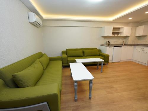 a living room with green couches and a table at gazelle suites in Istanbul