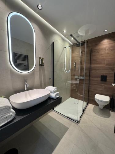 a bathroom with a sink and a glass shower at Castel de Pont-a-Lesse in Dinant
