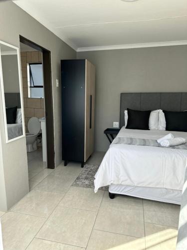 a bedroom with a large bed and a bathroom at Maphuthi River Lodge in Ga-Manapane