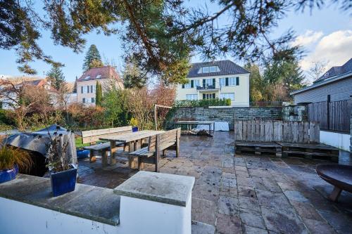 eine Terrasse mit Bänken und einem Tisch im Hof in der Unterkunft ZeitweiseHaus in Weingarten