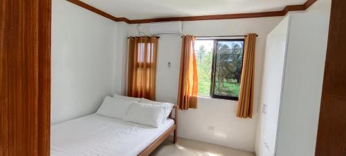 a small bedroom with a bed and a window at Casa Victoria Pension House-Star Maria in Somosomo