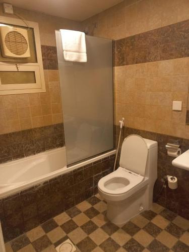 a bathroom with a toilet and a tub and a sink at Dar Al Amara in Muscat