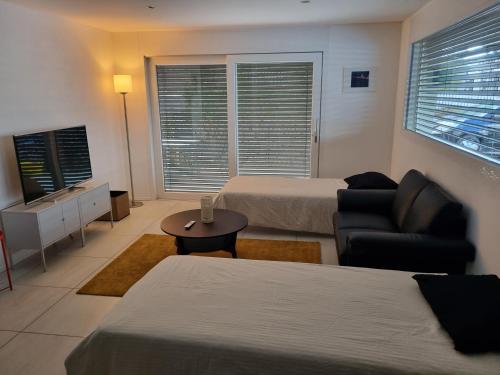 a hotel room with two beds and a couch and a table at Elegant Suites Murten in Murten