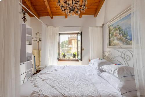 ein Schlafzimmer mit einem großen weißen Bett und einem Kronleuchter in der Unterkunft Affascinante appartamento nel Castello. in Moniga