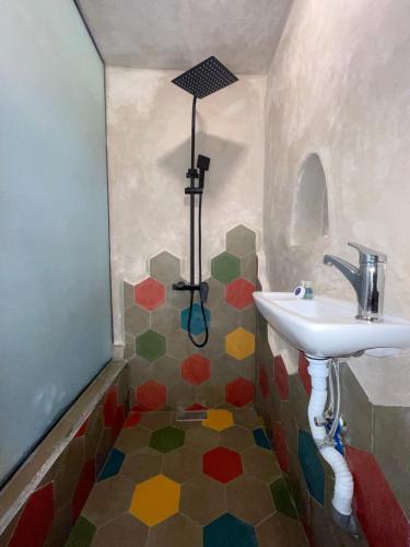 ein Bad mit einem Waschbecken und einer farbenfrohen Etage in der Unterkunft Le Studio 46 in Tangier