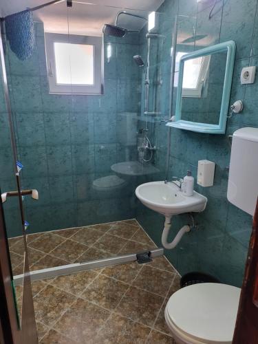 a bathroom with a sink and a toilet and a mirror at Studios Kalina in Budva