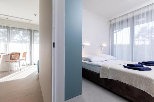 1 dormitorio con cama y ventana grande en HEVENIA POGORZELICA - APARTAMENT 1, en Pogorzelica