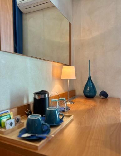 a table with cups and a lamp and a mirror at Acqua di Mare in Bordighera