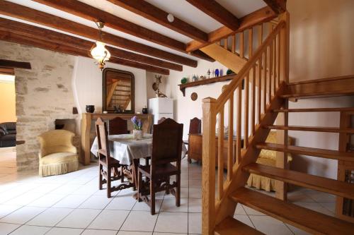 Bétoncourt-les-Ménétriers的住宿－Gîte Ai Ouillotte，一间带桌子和楼梯的用餐室