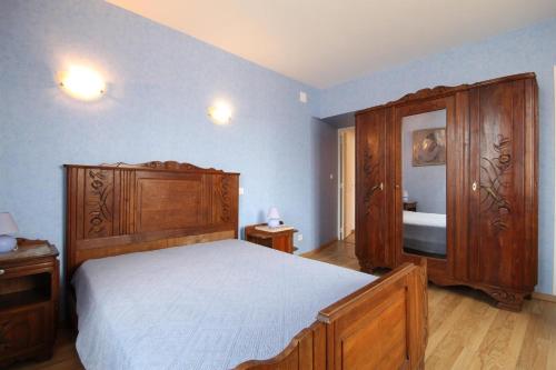 1 dormitorio con 1 cama y armario de madera en Gîte Ai Ouillotte en Bétoncourt-les-Ménétriers