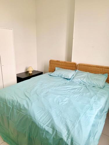 a bedroom with a bed with blue sheets and a side table at Festival de Cannes apartment in Cannes