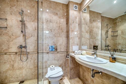 a bathroom with a shower and a toilet and a sink at Dreams in La Mer in Golden Sands