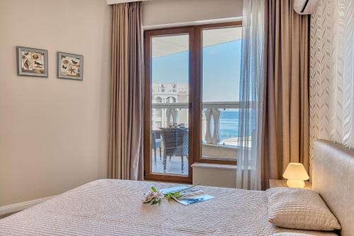 a bedroom with a bed and a window with a view at Dreams in La Mer in Golden Sands