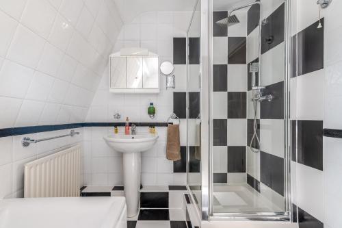 a bathroom with a sink and a shower at Charming 3-Bedroom London Townhouse Balcony in London