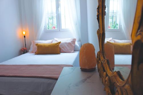 1 dormitorio con 2 camas y espejo en El Rincón del Azahar, dúplex con encanto, en Córdoba
