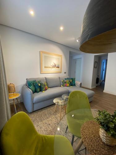 a living room with a couch and green chairs at Charito 18 in Cádiz