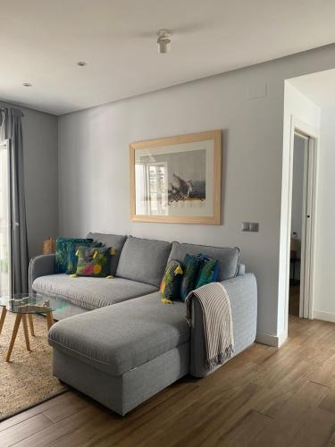 a living room with a gray couch and a table at Charito 18 in Cádiz