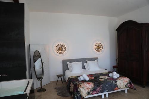 a bedroom with a bed and a mirror and a television at Domaine de la Vidalle in Vendres