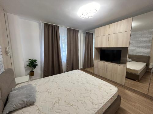 - une chambre avec un lit et une télévision à écran plat dans l'établissement Risen, à Floreşti