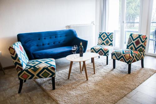 a living room with a blue couch and chairs and a table at Sun Valley Apartments in Maishofen