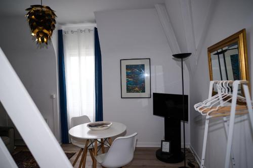 een witte woonkamer met een tafel en een bed bij Les Salins de Batz-sur-mer in Batz-sur-Mer